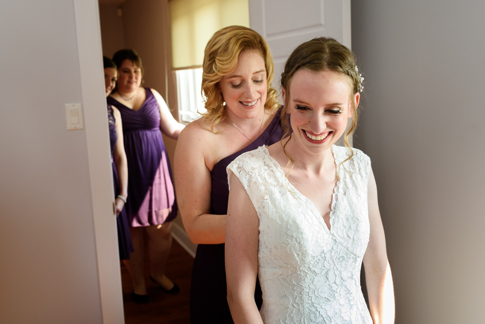 Bride's sister doing up her dress