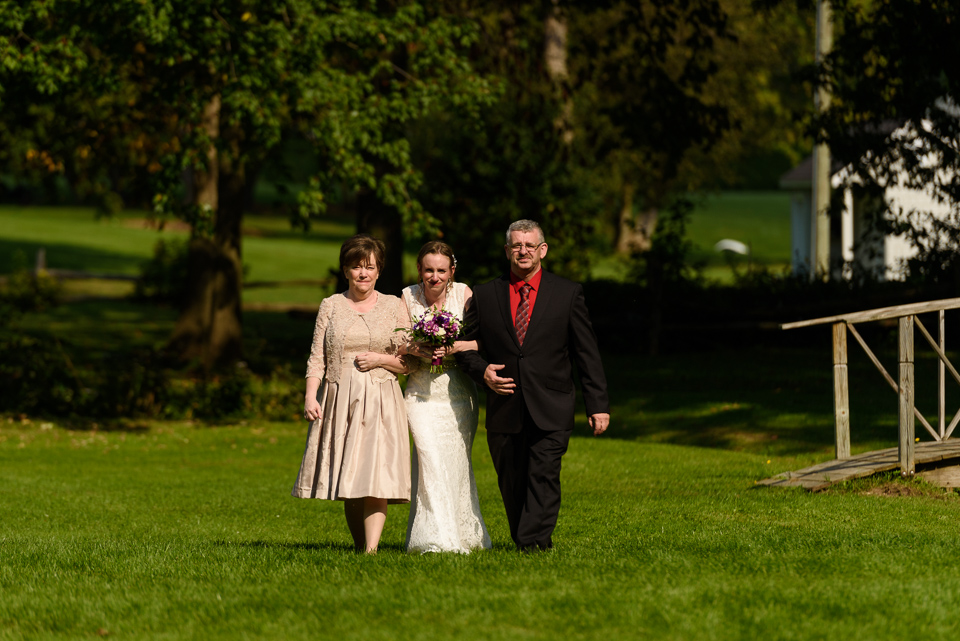 Bride and parents walking to wedding ceremony