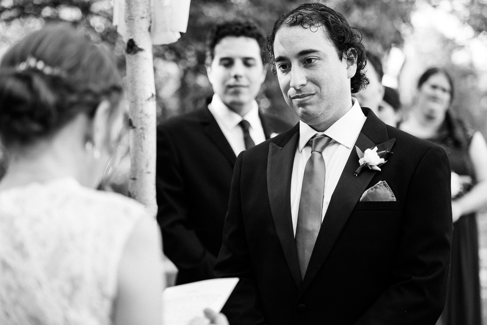 Groom looking at bride during outdoor wedding ceremony