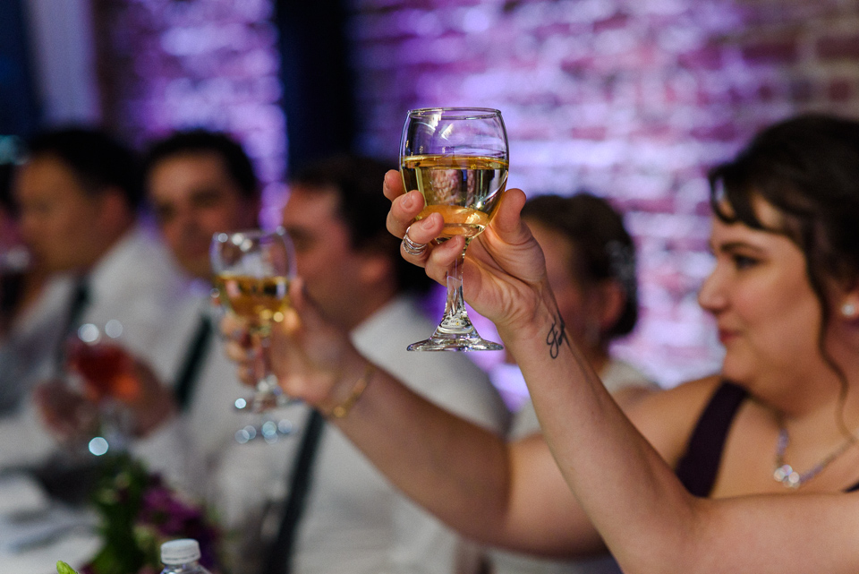 Glasses raised in toast at Canvas Loft reception hall