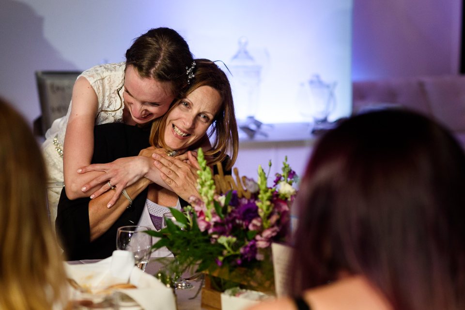 bride giving hug to wedding guest