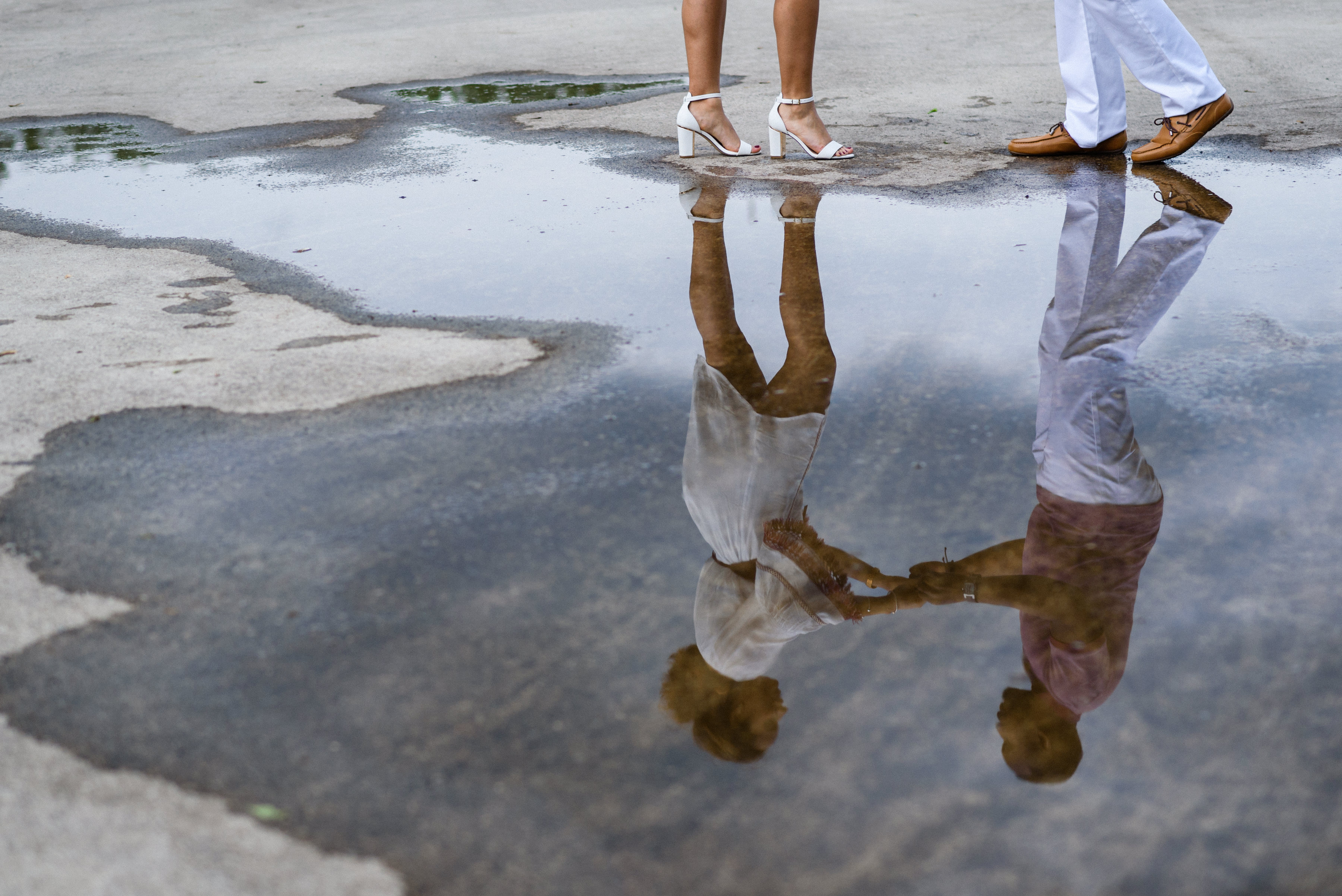 Couple dancing in a rain puddle