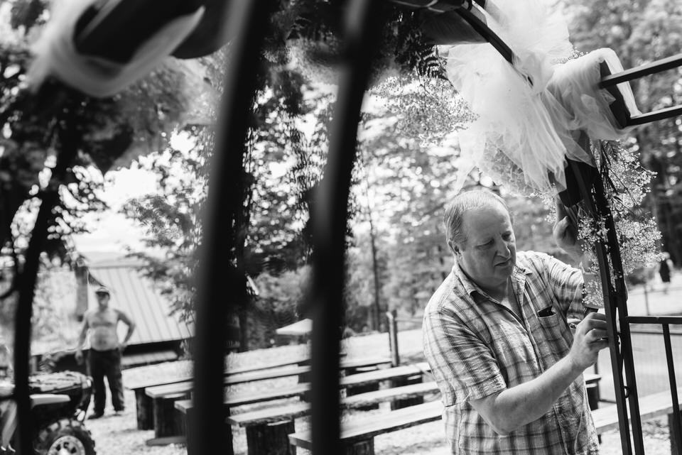 Man setting up the floral wedding arch