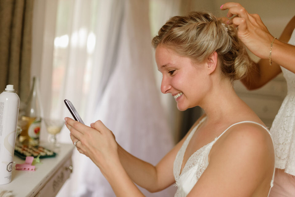 Bride laughing and texting someone