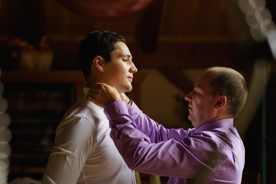 Father of the groom helping him with his bow tie