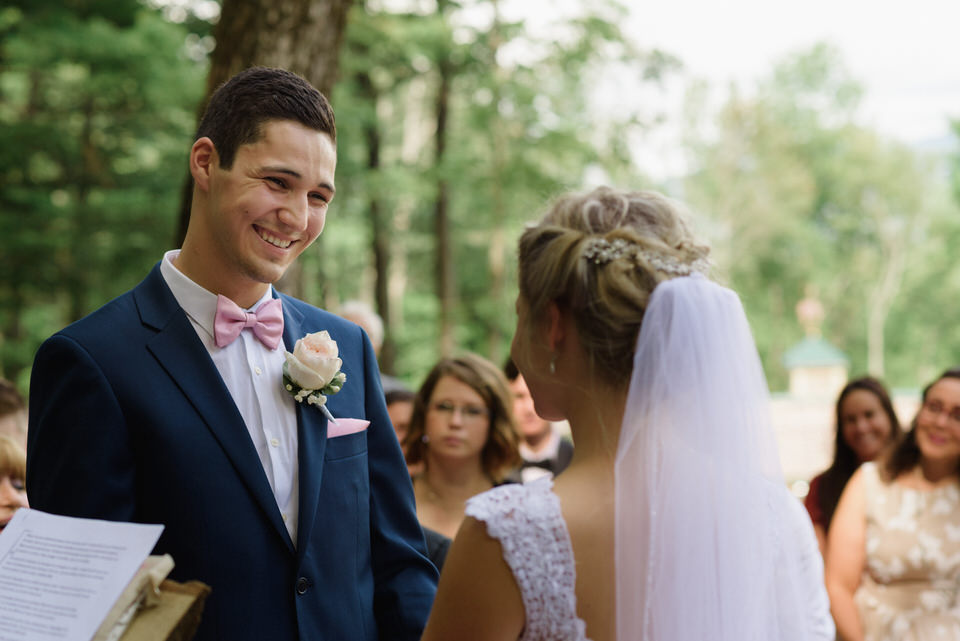 Groom smiling down at bride during wedding ceremony