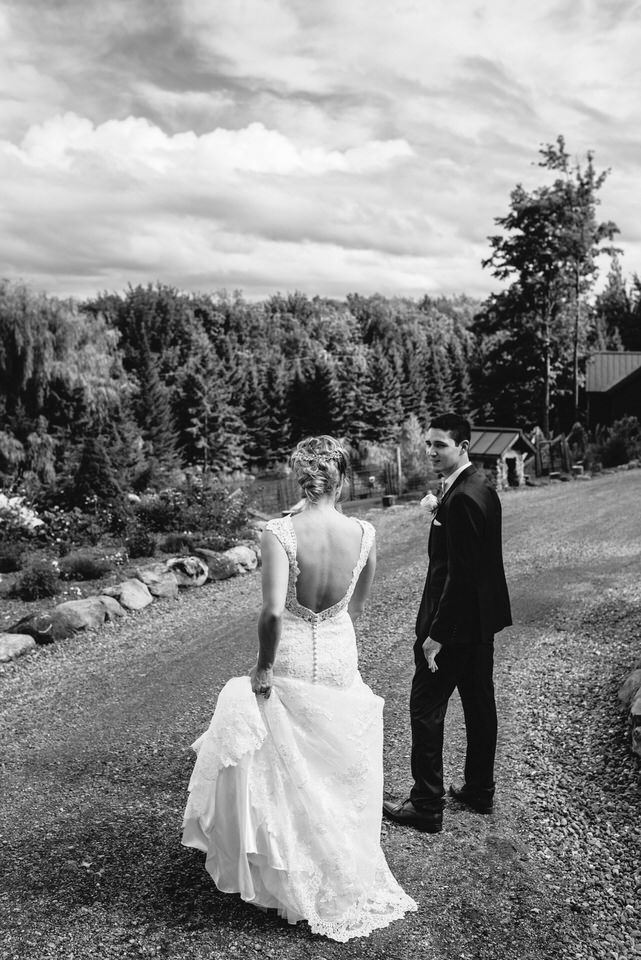 Bride and groom walking down gravel path in mountains in Eastern Townships