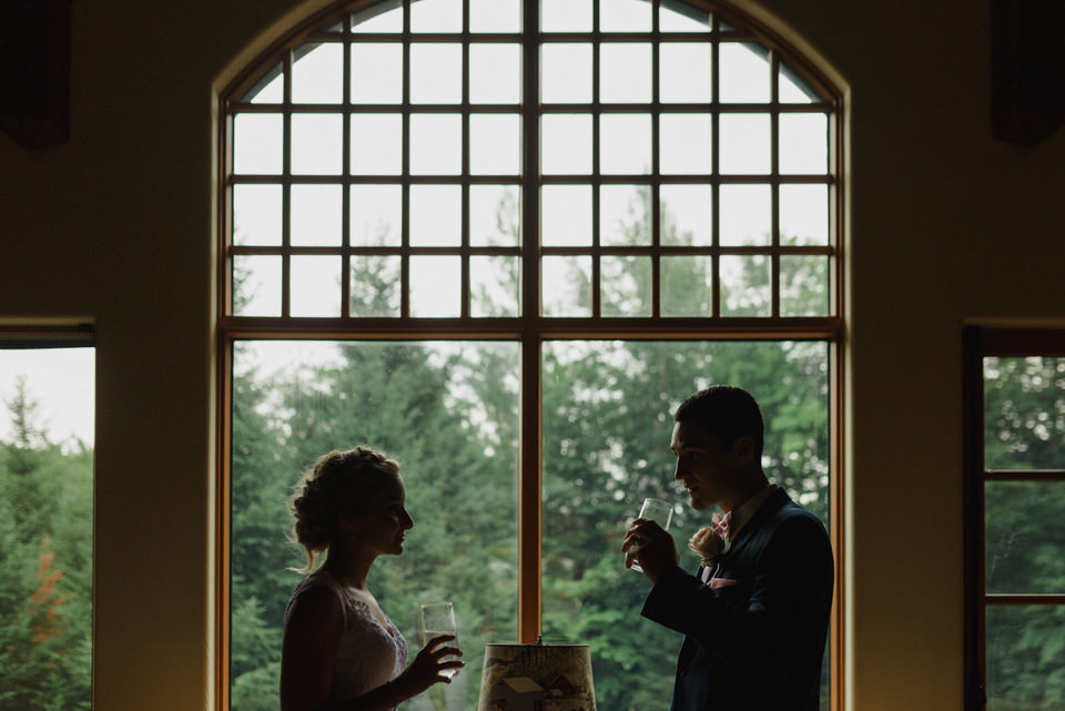 Silhouette of wedding couple drinking water in rustic cabin