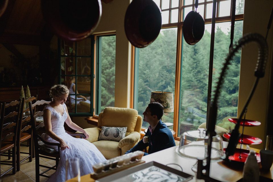 Bride and groom sitting inside rustic cabin