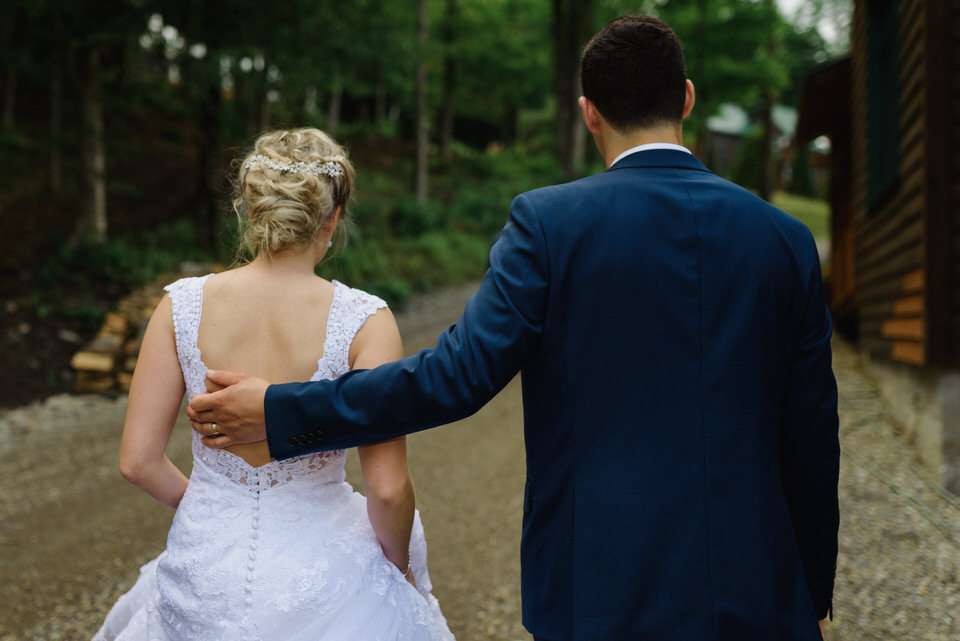 Bride and groom walking up forest road