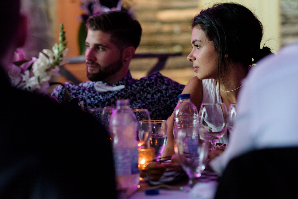 Wedding guests at dinner with candlelight under tent