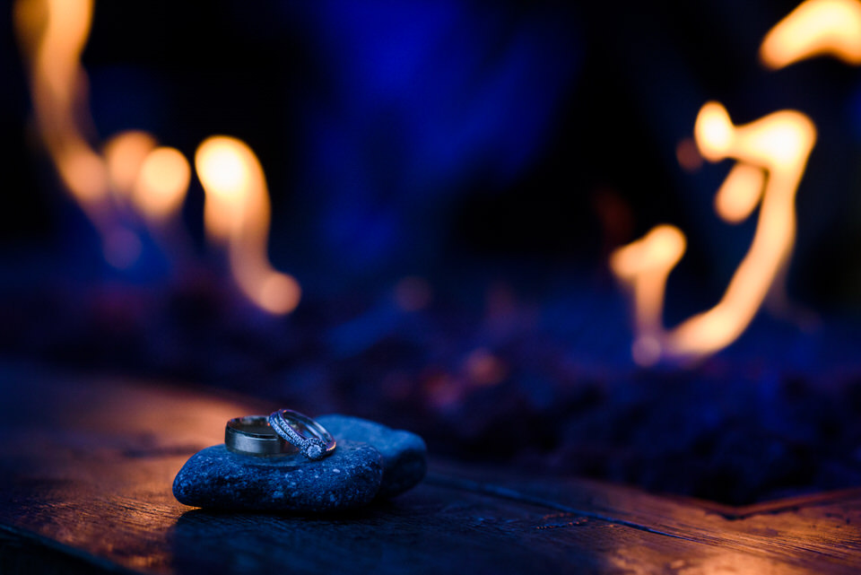 Close up of wedding rings with flames behind