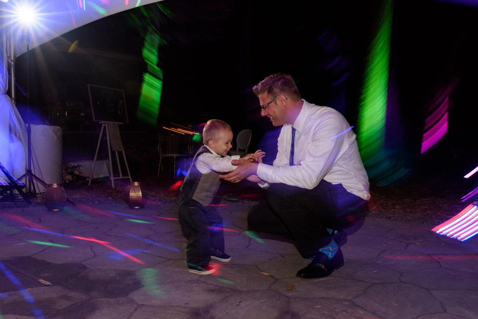 Man dancing with his child at wedding