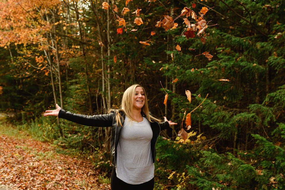 Woman throwing fall leaves into the air