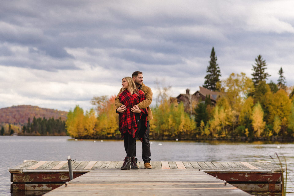Couple hugging on dock with view of lake behind