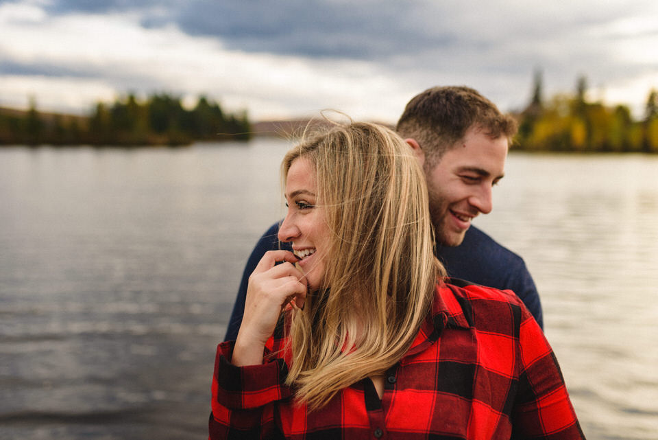 Couple smiling and hugging in front of a lake