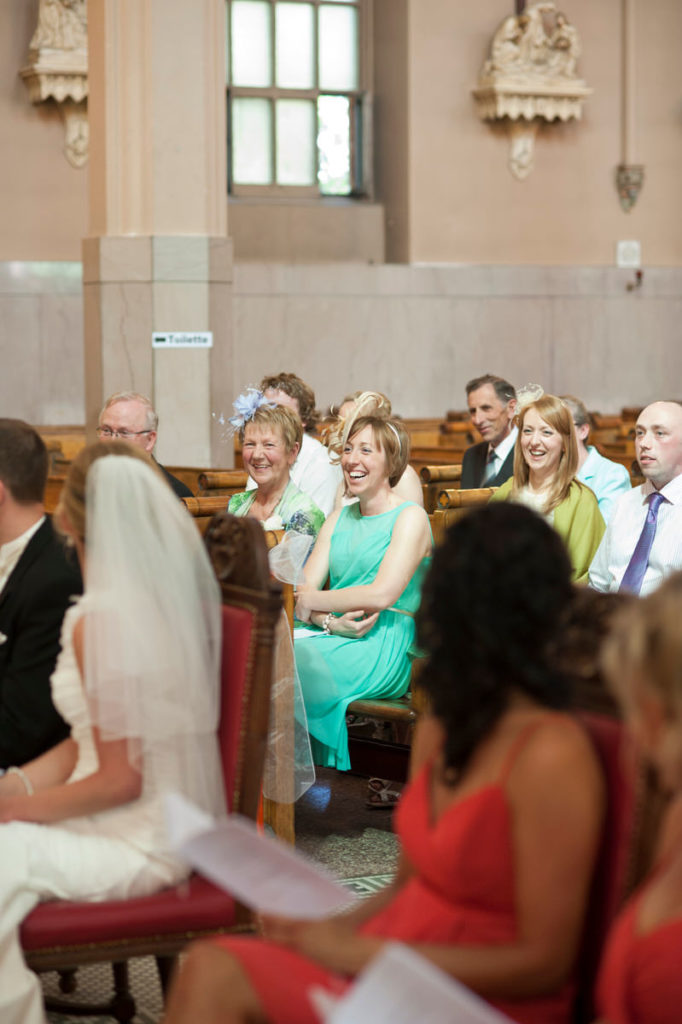 Wedding guests laughing during ceremony