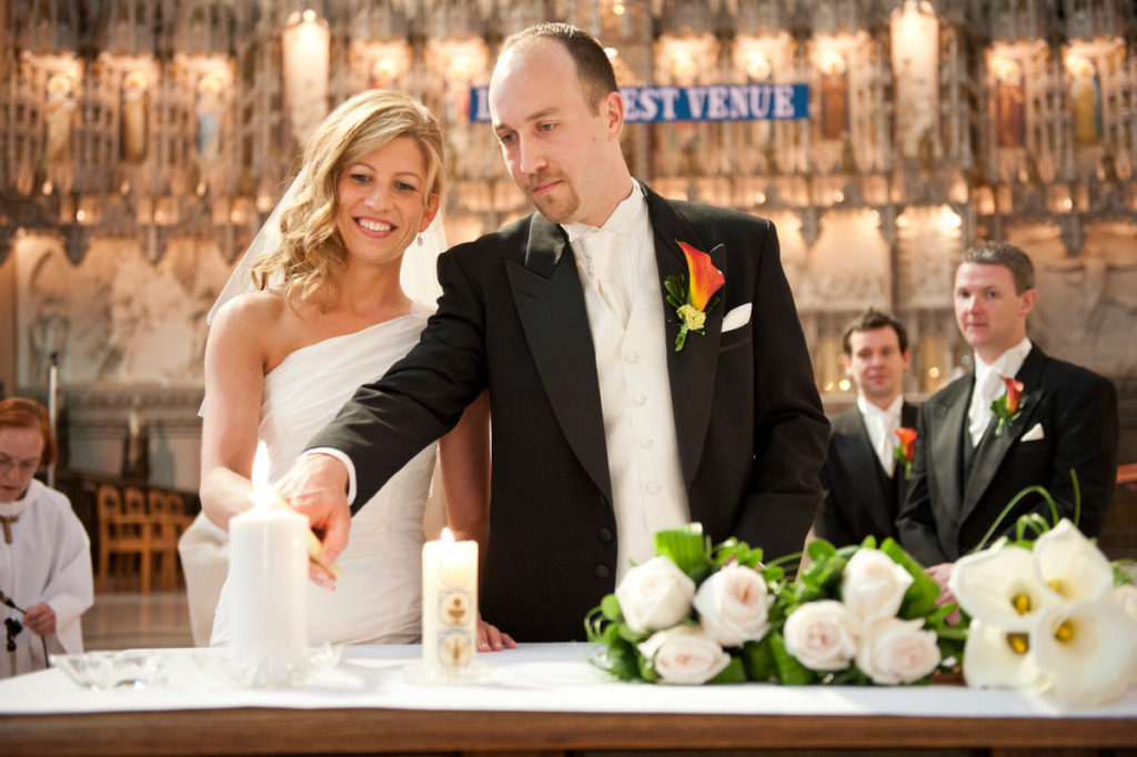 Wedding couple lighting a candle together