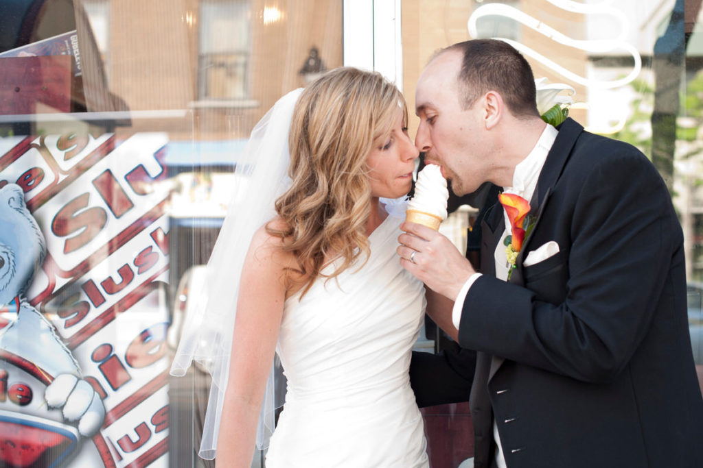 Bride and groom eating ice cream on the street