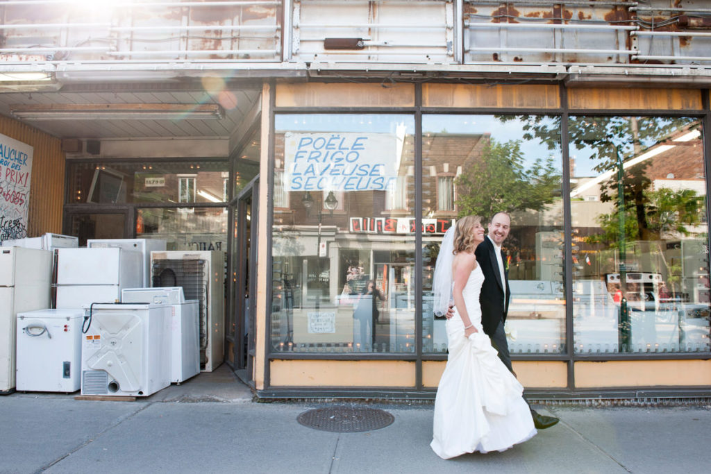 Wedding couple walking by a rundown appliance store