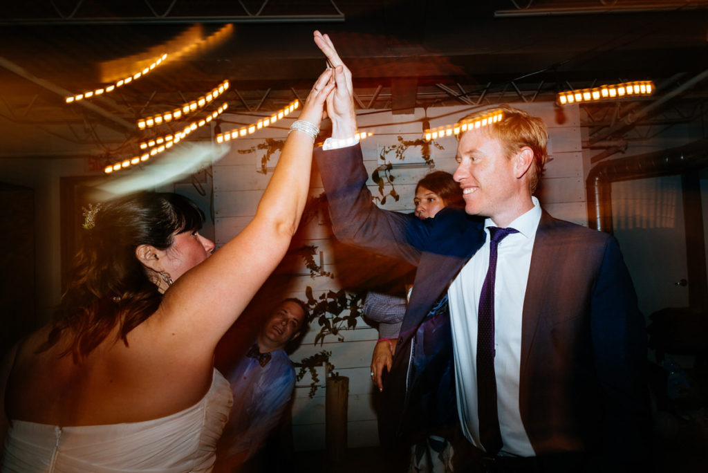 Bride high fiving her friend during wedding night