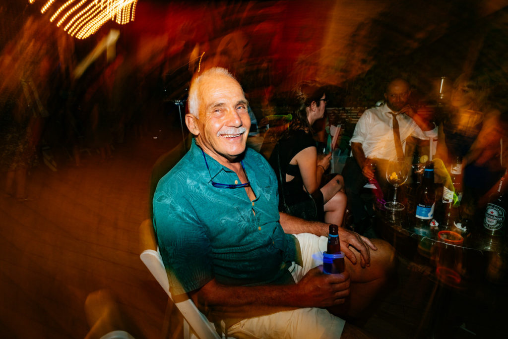 Groom's step dad smiling at camera during wedding night