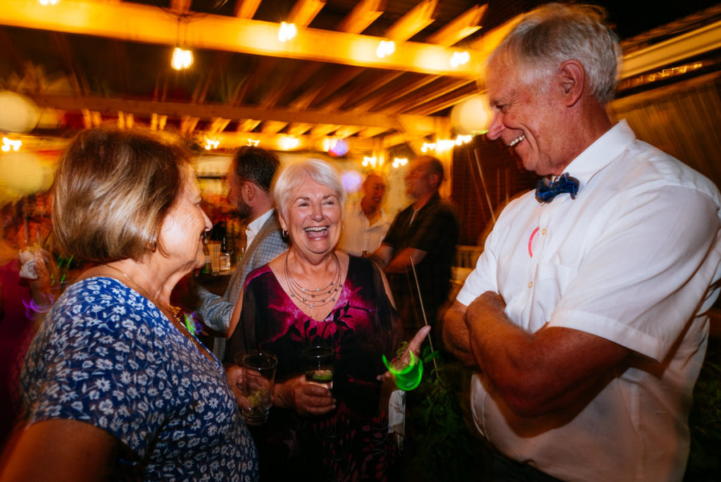 Bride's mom laughing with guests during wedding reception