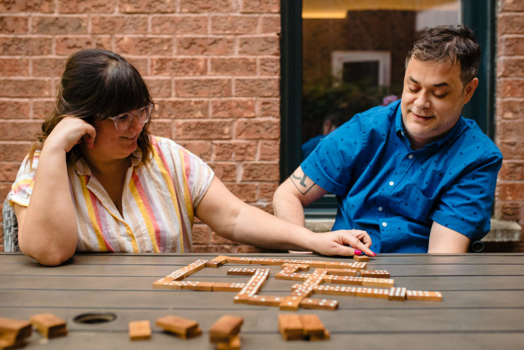 At-home engagement photo of couple playing dominoes