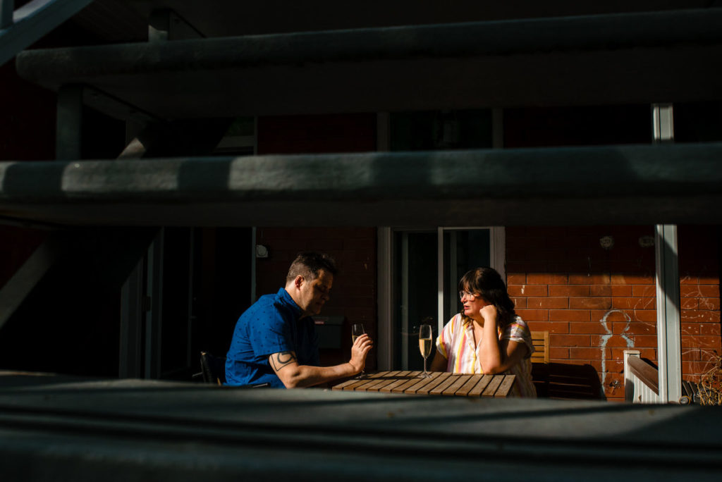 Engaged couple chatting in the sunset on their porch