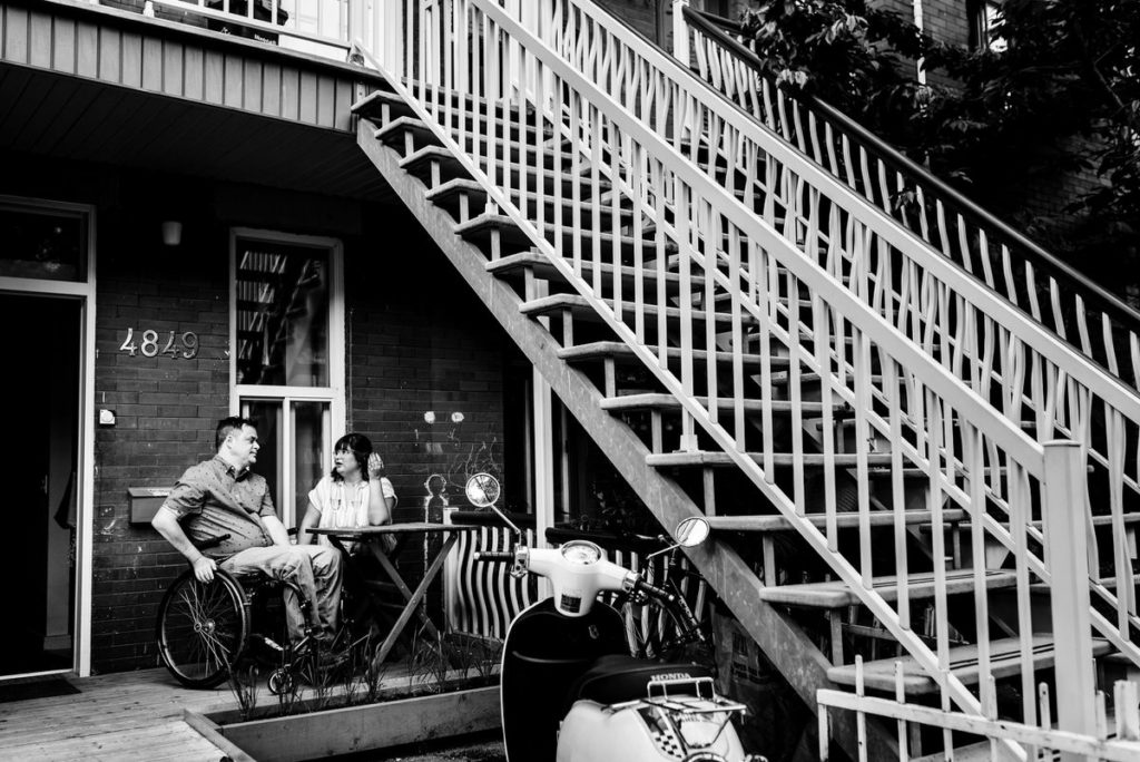 At-home engagement photo at their front porch patio table