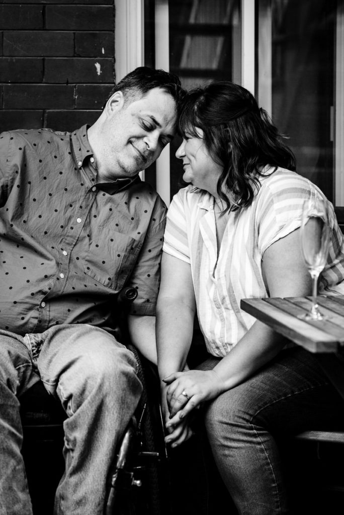 couple holding hands with champagne glasses on porch