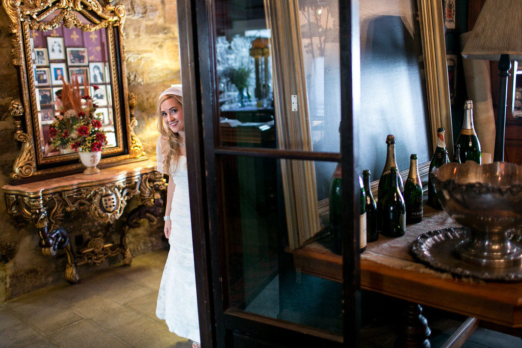 Bride peeking around corner of room at Pierre du Calvet hotel