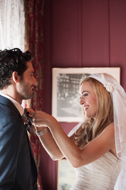 Bride fixing the groom's bow tie