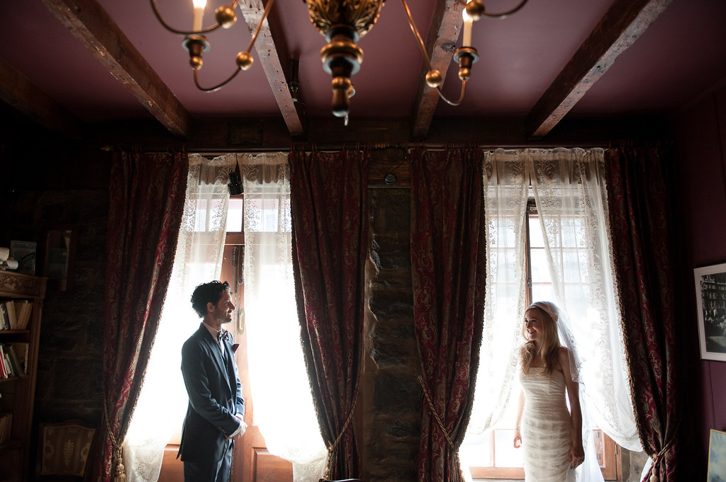 Wedding portrait of bride and groom standing in window at Pierre du Calvet Hotel