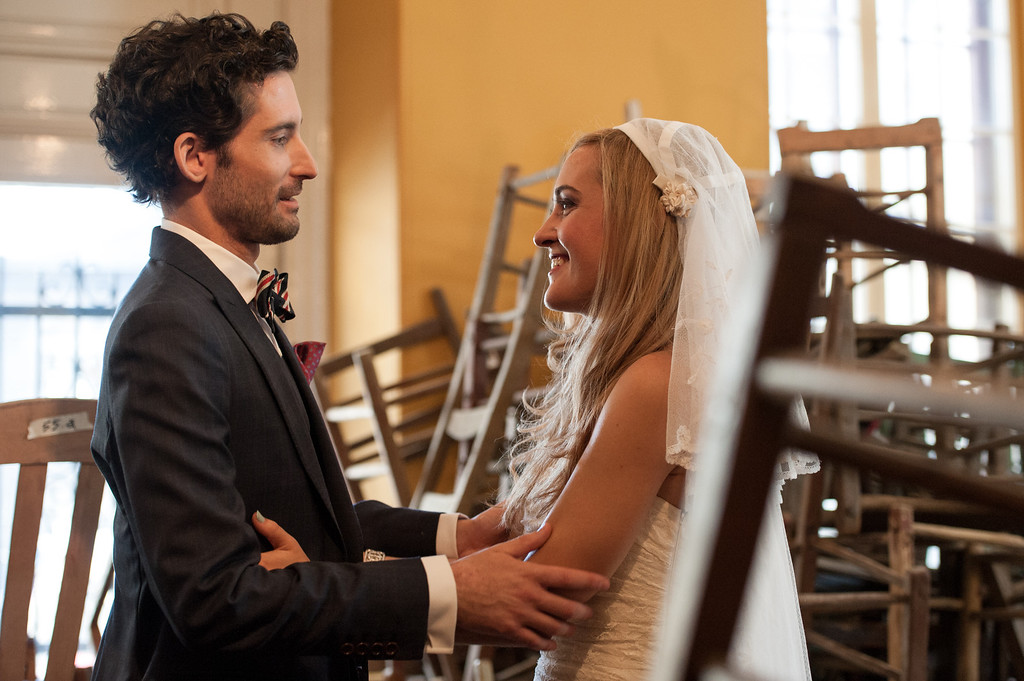 Wedding couple in room full wooden chairs