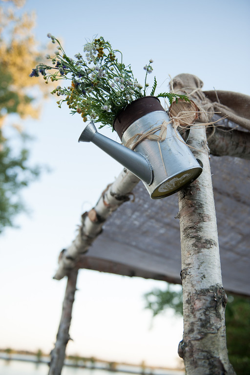 Rustic wedding decoration of watering can on huppa