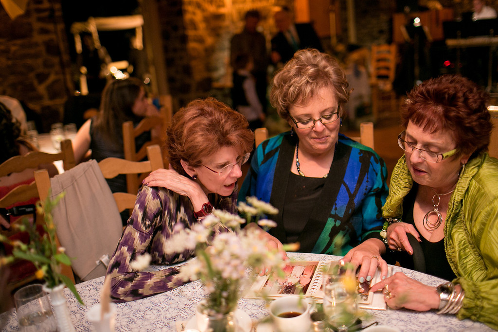 Family members looking at old wedding albums during reception