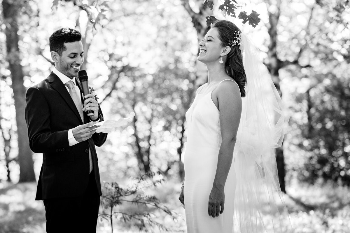 Bride laughing during the groom's wedding vows