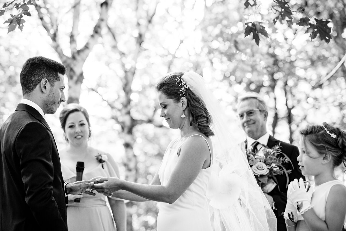 Bride putting ring on groom's finger