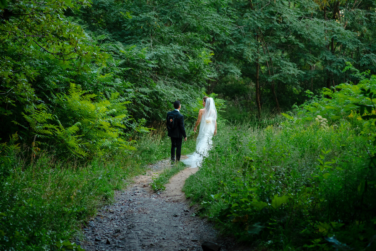 Wedding couple walking in the green woods on Mount Royal
