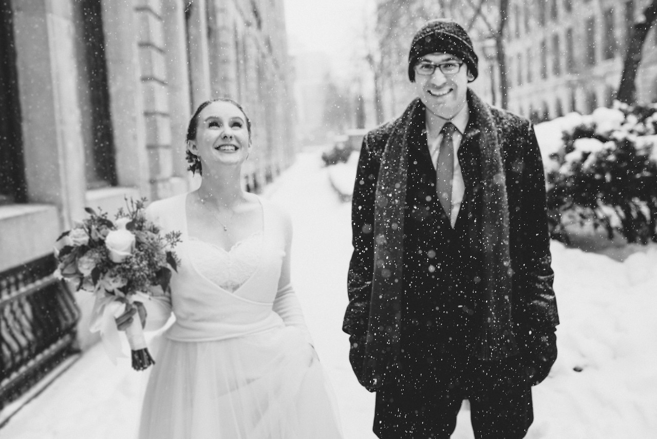 Bride and groom staring at snow floating down