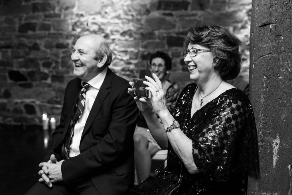 Groom's parents laughing and taking a photo during the ceremony