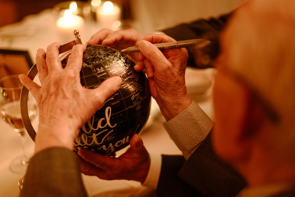 Wedding guest signing the globe guestbook