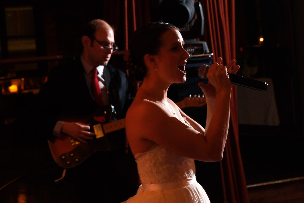 Bride singing as groom plays guitar 3