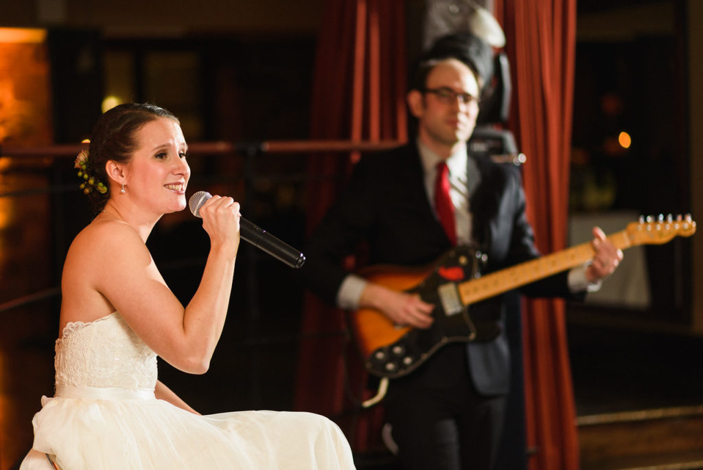 Bride singing as groom plays guitar