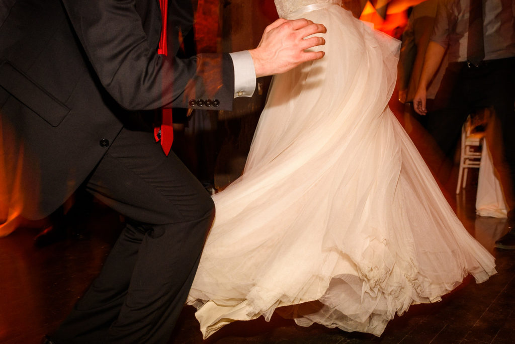Close of up bride's wedding dress spinning as they dance together