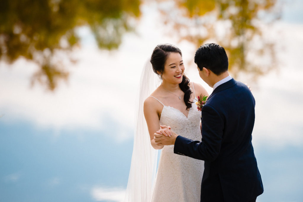 Bride and groom practicing their dancing by a pond