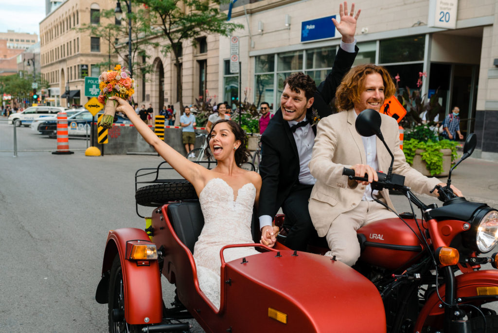 Bride and groom driving off on a motorcycle with sidecar