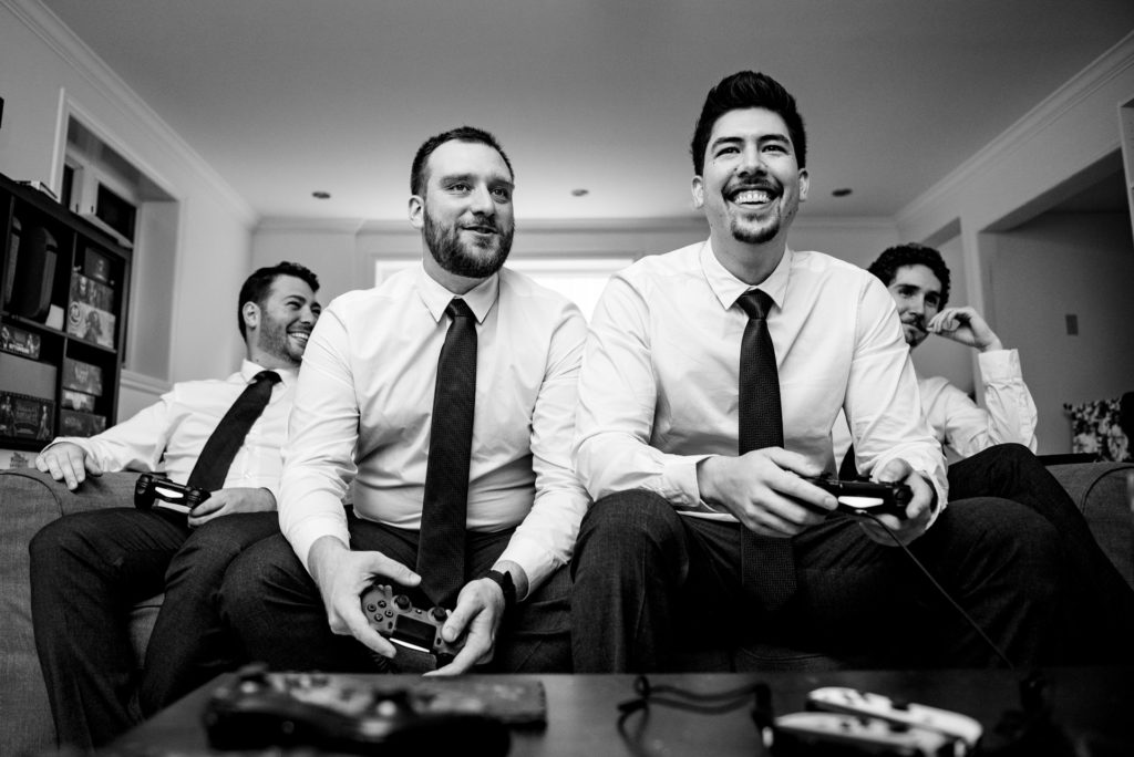 Happy groomsmen playing video games