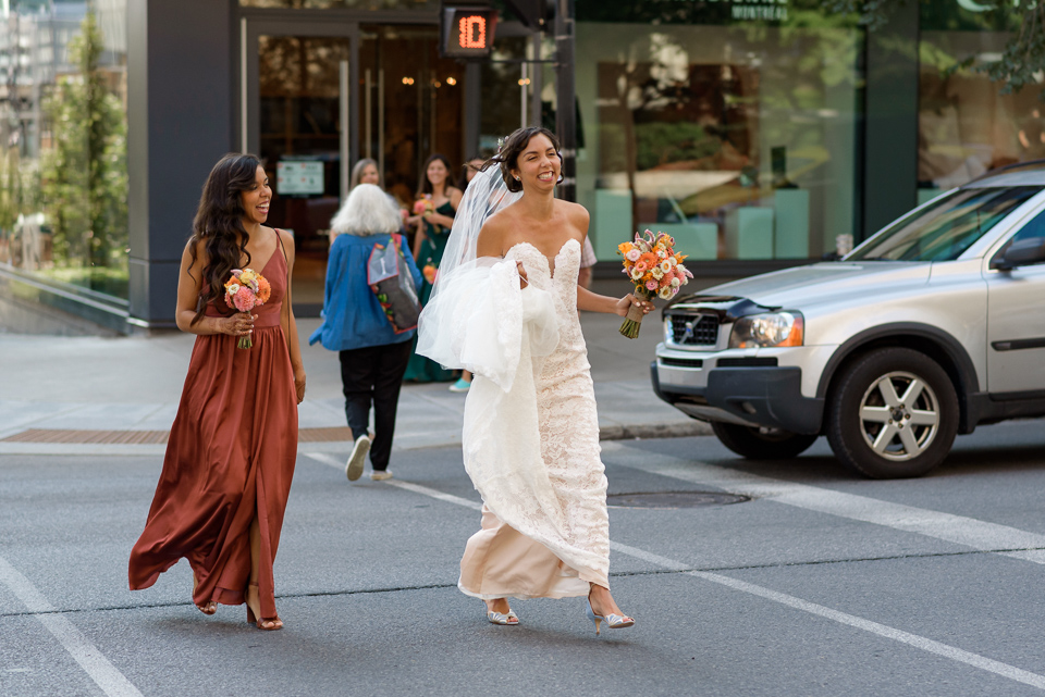 Bride and her sister running across the street